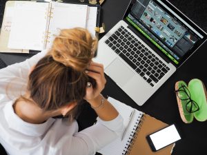 Frau beugt sich über Laptop